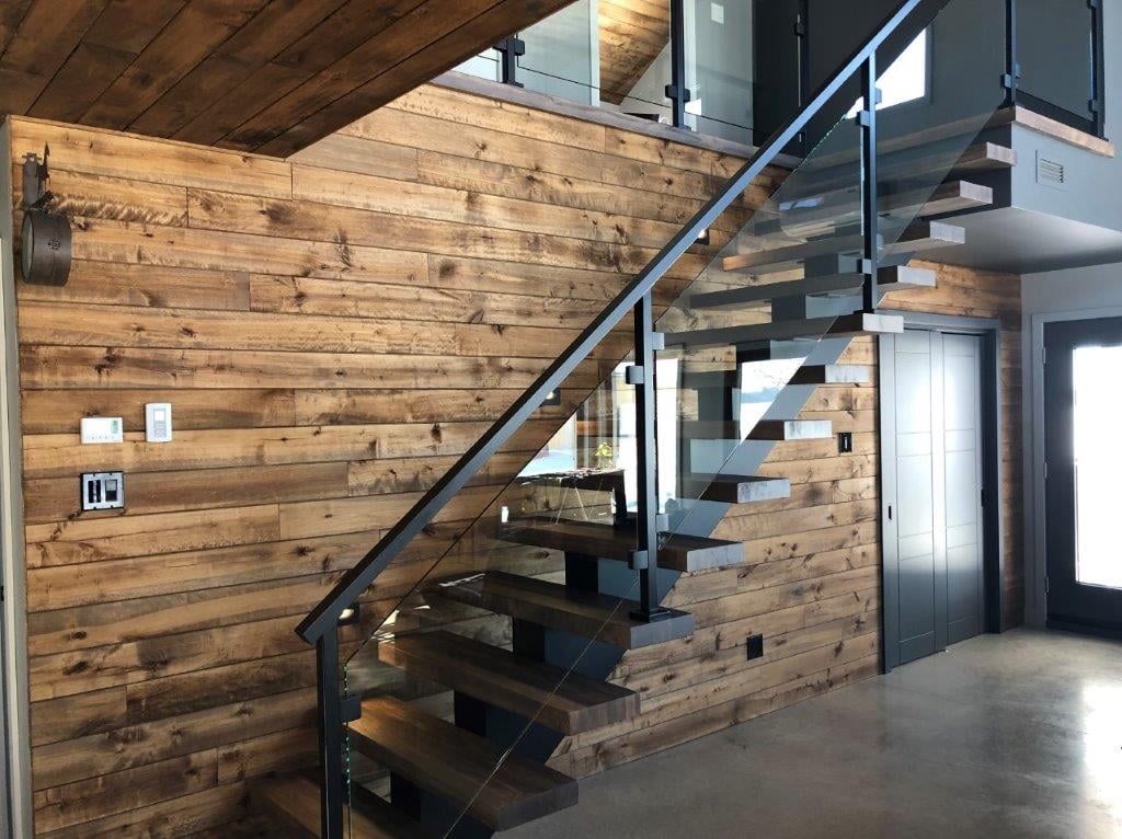 Escalier moderne en bois avec garde-corps en verre.