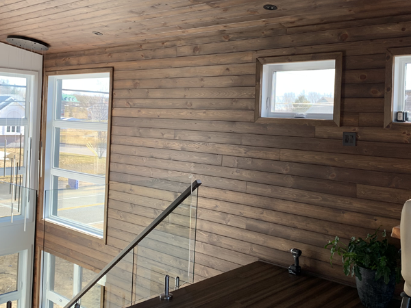 Intérieur avec murs en bois et fenêtres lumineuses.